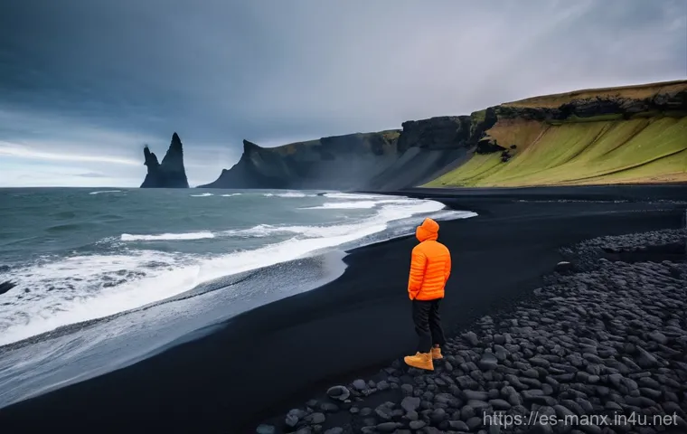 맨섬 vs 아이슬란드 - **Iceland's Volcanic Coastline Adventure:**
    A solo traveler, seen from a respectful distance, st...